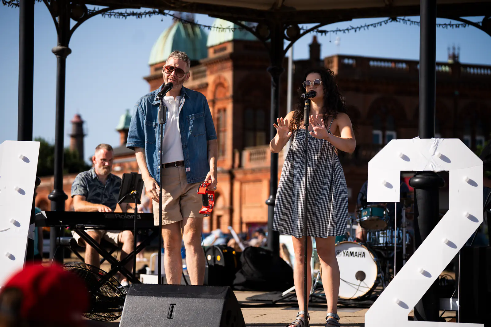 Singers performing on the bandstand with the Pavilion Theatre behind them