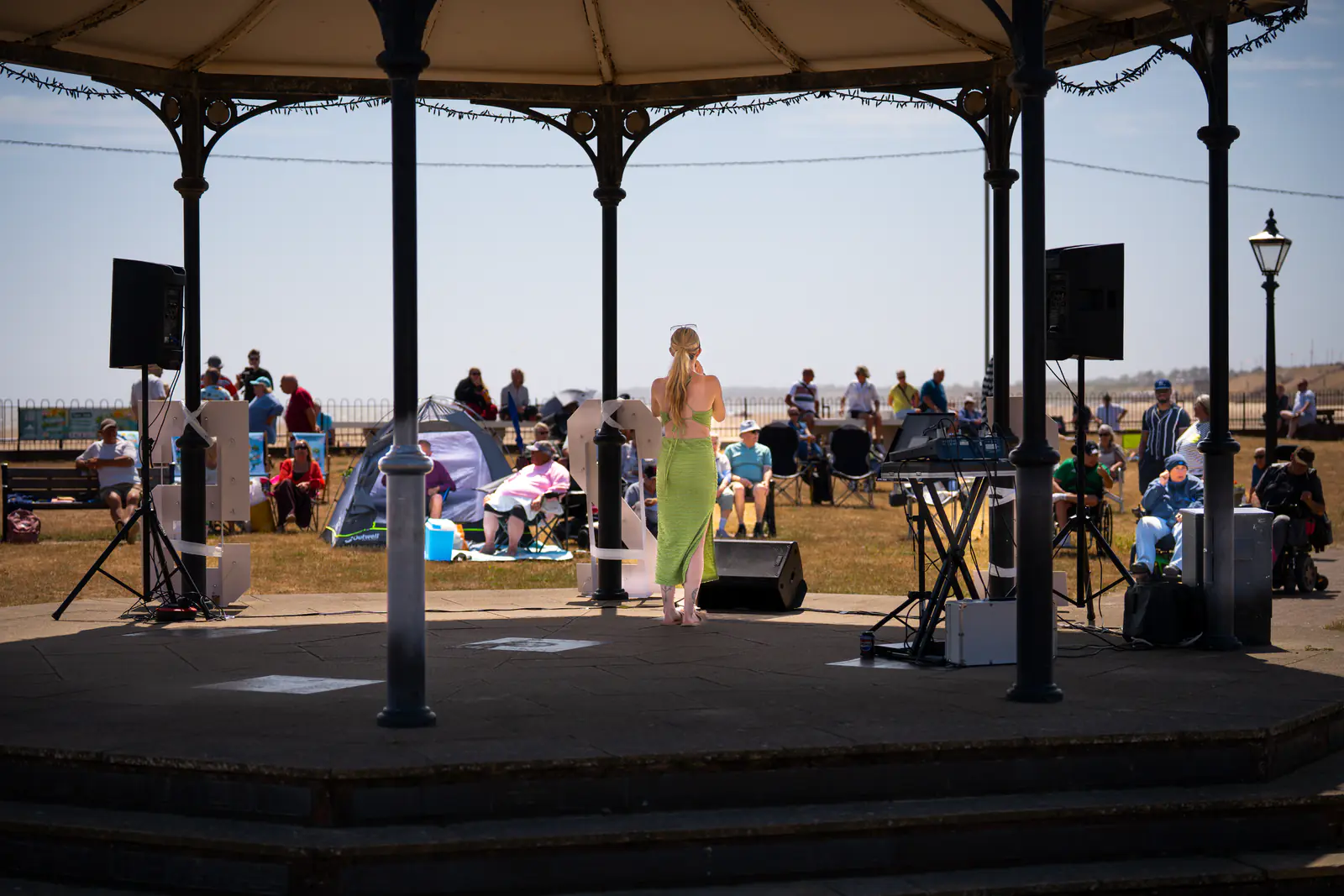 A performer looking out from the bandstand towards the celebration audience