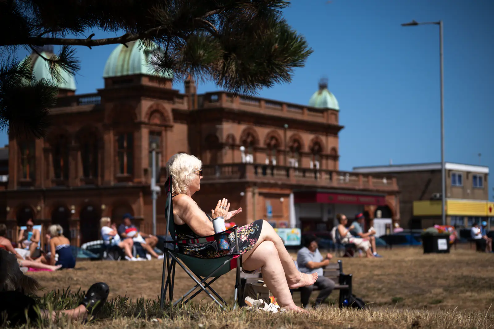 An audience member applauding with the Pavilion Theatre behind her