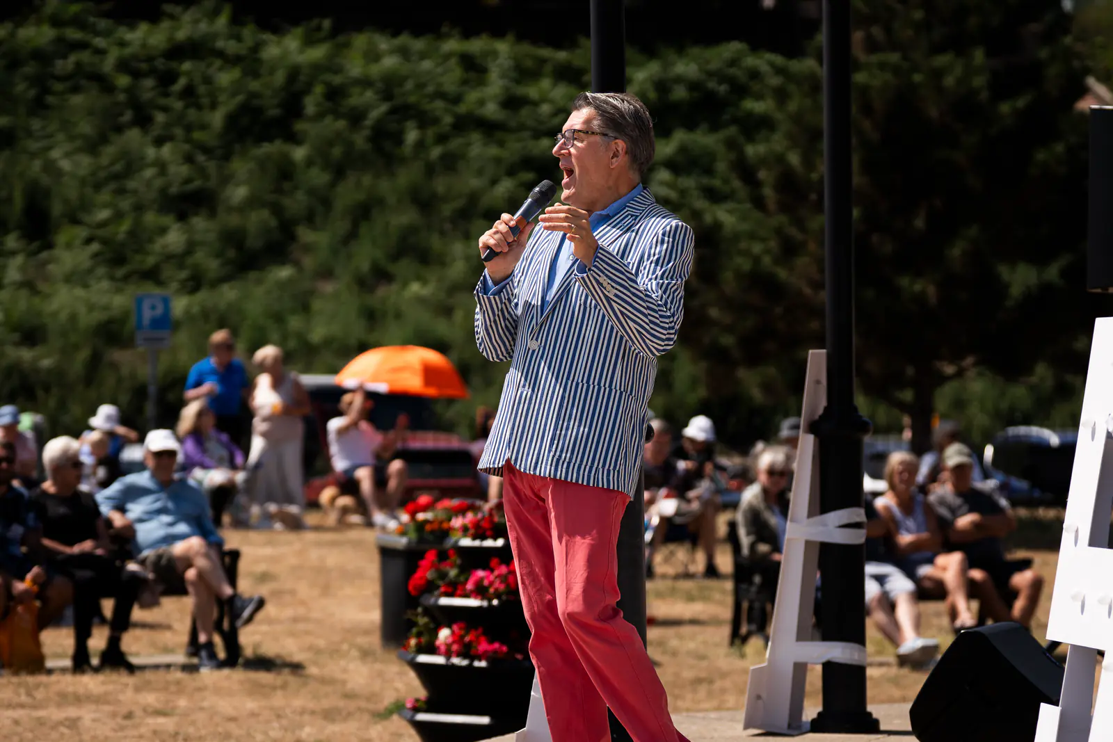 The birthday celebration compère performing for the bandstand audience
