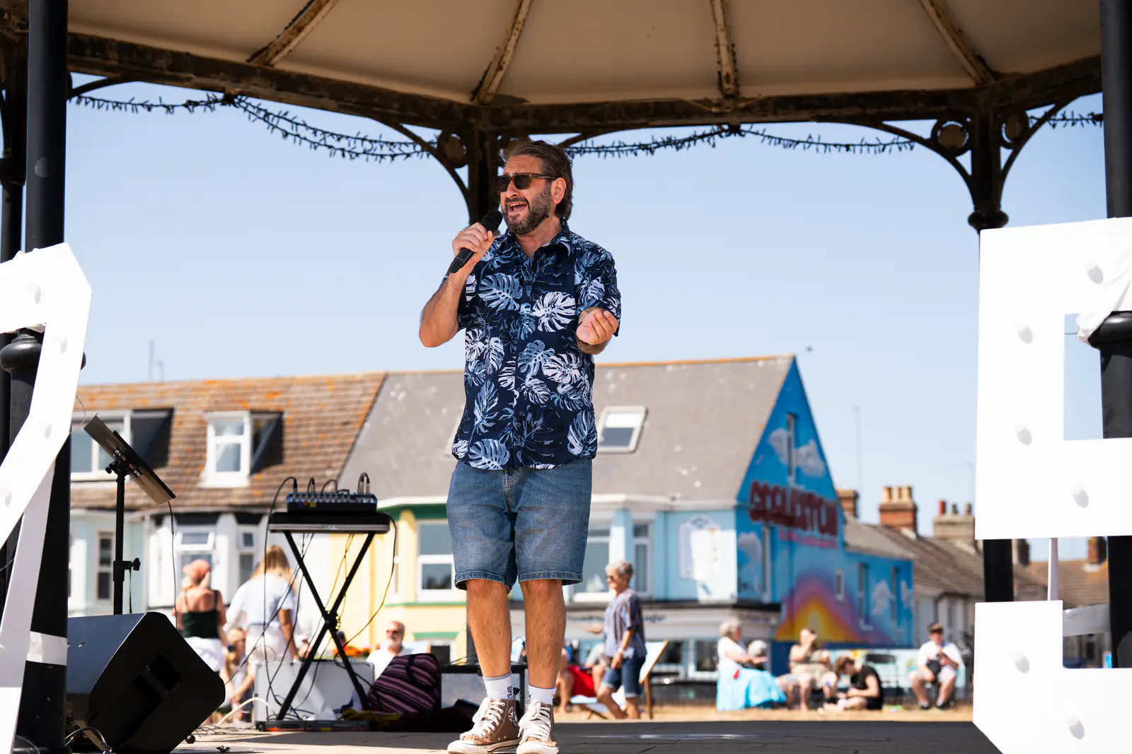 A singer performing between the illuminated 125 numbers on the bandstand