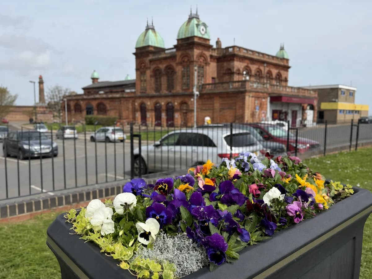 Colourful planters with Gorleston Pavilion Theatre behind them