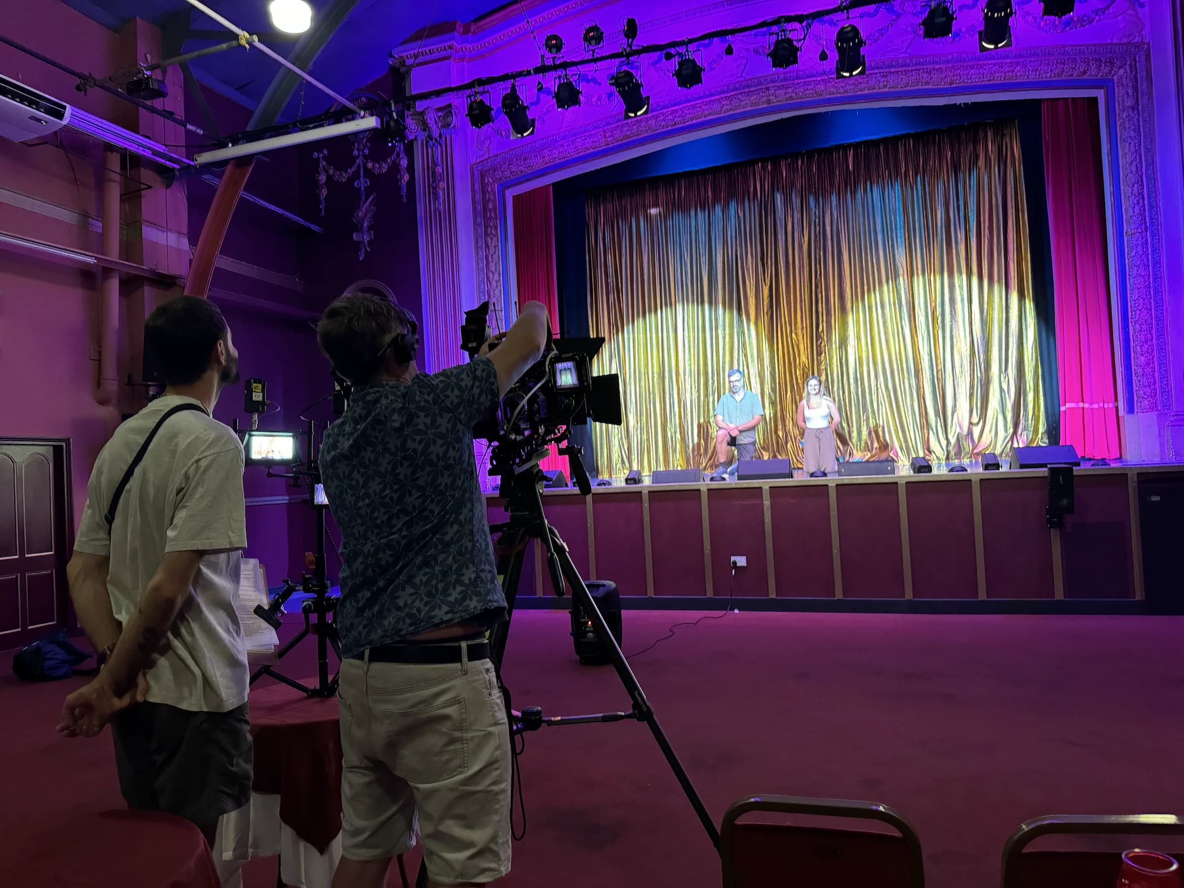 A television crew filming two contributors on the Pavilion Theatre stage