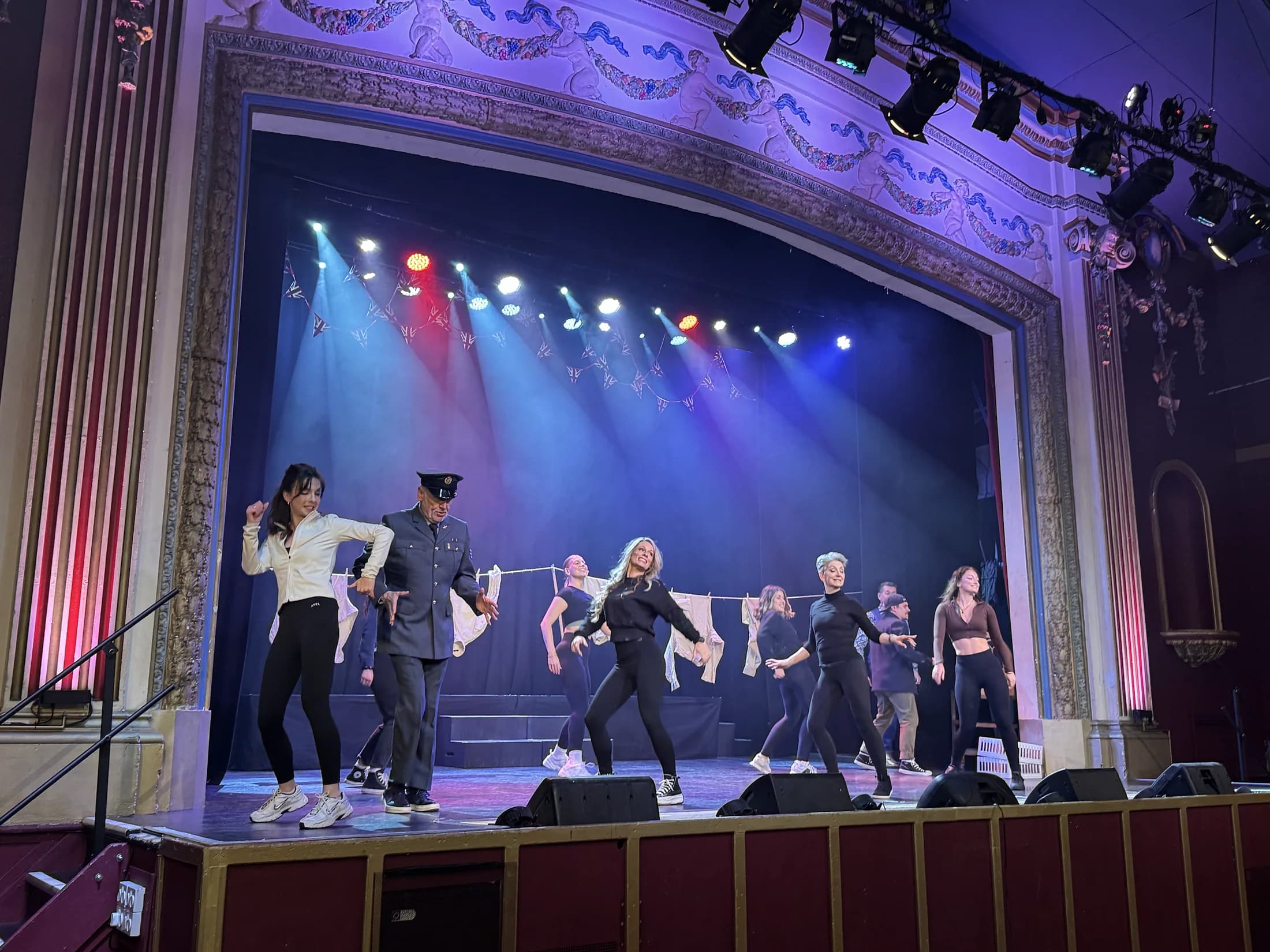 The VE Day ensemble performing a choreographed number on stage