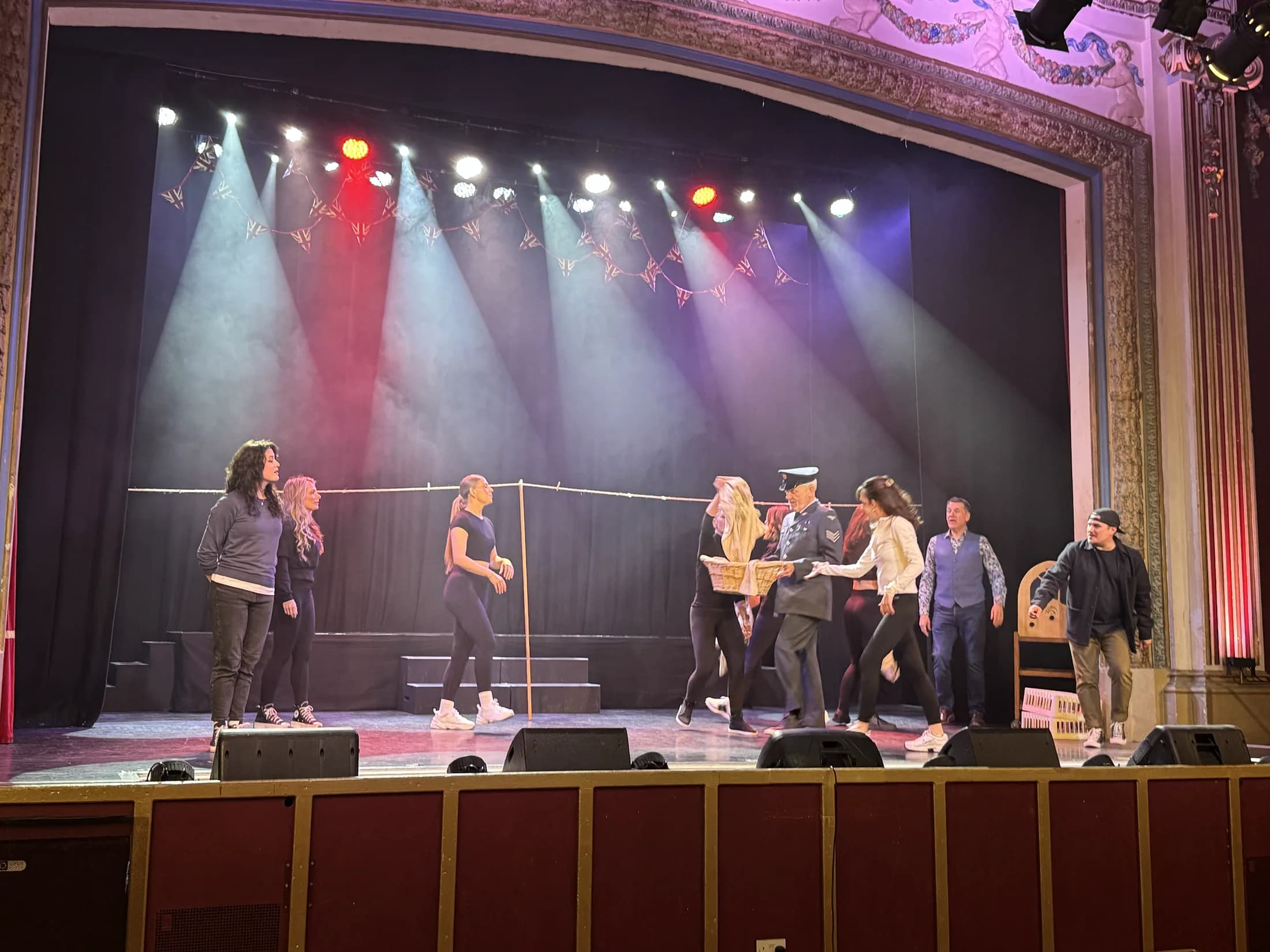The VE Day cast performing beneath colourful Pavilion stage lighting