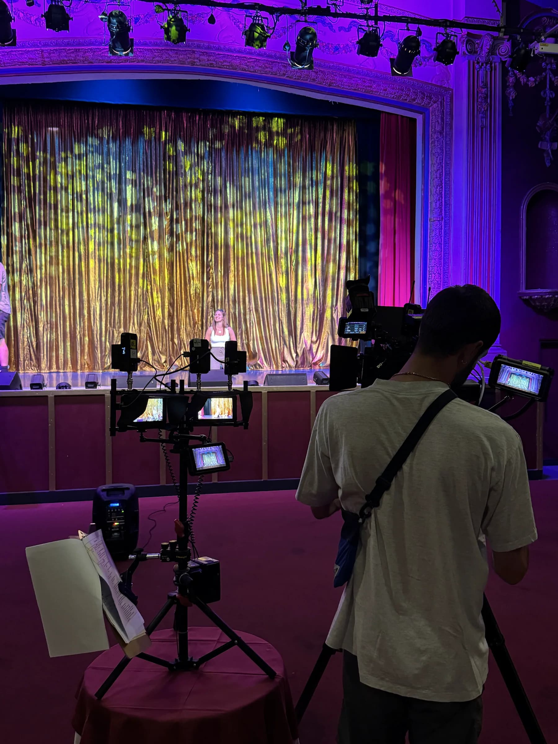 A camera operator filming a presenter on the Pavilion Theatre stage