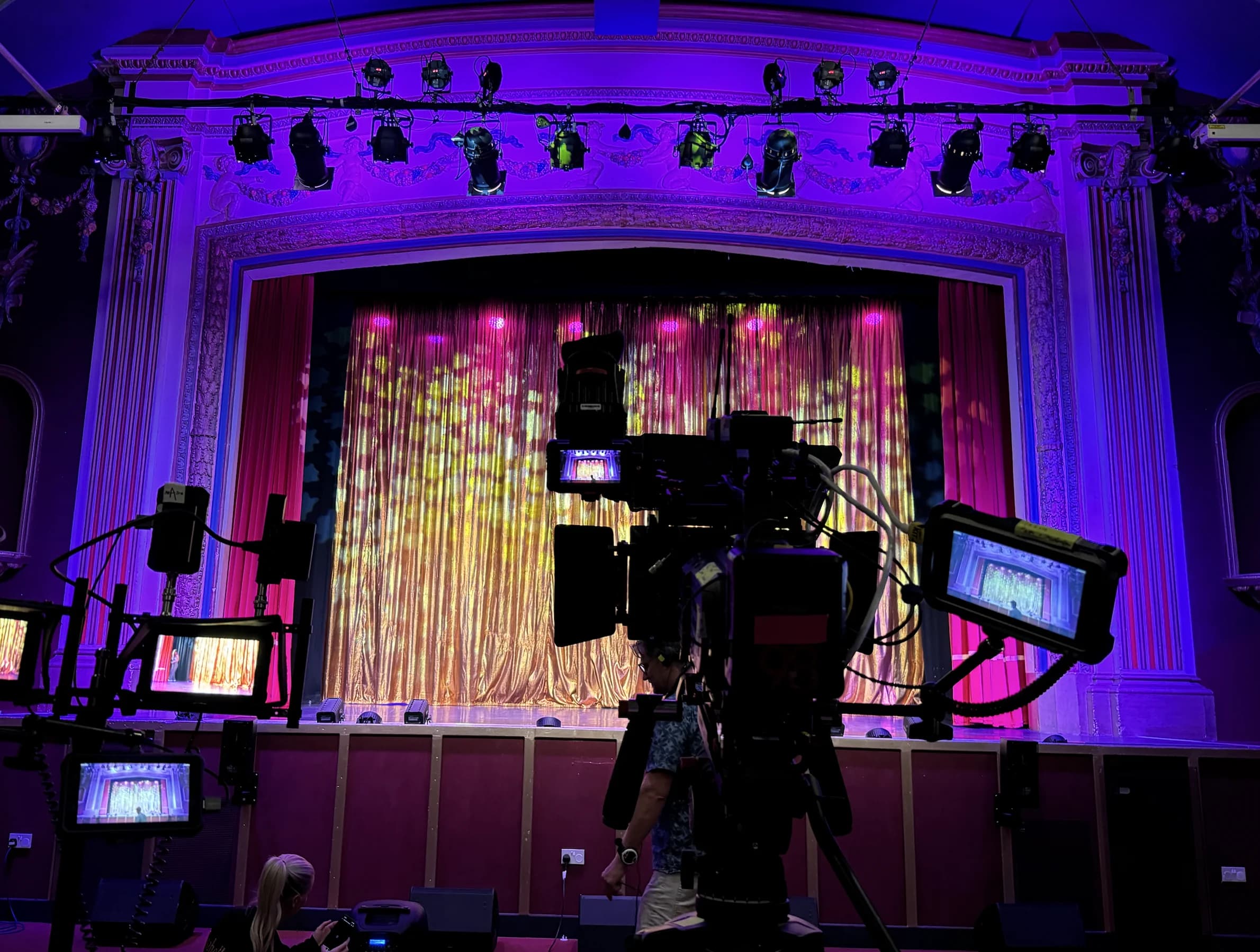 A broadcast television camera set up in front of the Pavilion Theatre stage
